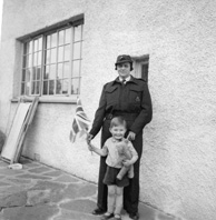 Stella Paterson wearing Civil Defense uniform with nephew Gilbert Paterson, at 7 Culduthel Gardens, Inverness c1945-1946. Her husband was Hector Paterson, son of famous photographer Andrew Paterson (1877-1948).
