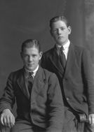 Two young men, one seated, possibly brothers.#    