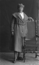 Young woman standing in overcoat. Slightly blurred image.#    