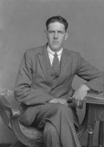 W. MacLean, seated with legs crossed.