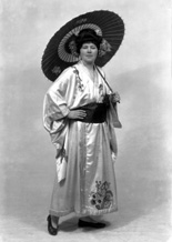 Carrie M. Cruickshank as Mimosa in the November 1927 production of 'The Geisha,' the story of a Japanese tea-house performed by the Northern Amateur Operatic Society. In the advert it was noted that prices would be increased for this attraction due to the lavish expense of the production (over ?200), in aid of the Queen Victoria Jubilee Institute for Nurses. A review noted that 'Miss Cruickshank has a beautiful voice, and went through the delicate Mimosa's ordeals of being sold and of selling with a sure finish.' #