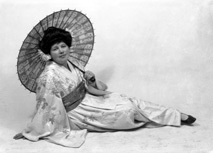 Carrie M. Cruickshank as Mimosa in the November 1927 production of 'The Geisha,' the story of a Japanese tea-house performed by the Northern Amateur Operatic Society. In the advert it was noted that prices would be increased for this attraction due to the lavish expense of the production (over ?200), in aid of the Queen Victoria Jubilee Institute for Nurses. A review noted that 'Miss Cruickshank has a beautiful voice, and went through the delicate Mimosa's ordeals of being sold and of selling with a sure finish.' #