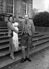 Parents on steps, at time of baby christening.#