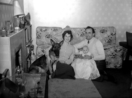 Family and dog in sitting room, taken for a Christmas card. Name on envelope is Helen Marie. #