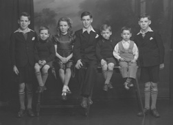 Stewart, Kessock Avenue, Inverness. Jimmy (far left) was twin brother to Sandy (far right). Willy (second left) was twin brother to Robert (third right). Mary and John. John was born a twin to Peter who died at 3 months. George Stewart (second right) is the only surviving sibling (2012). Unsure why the negative envelope has the address as Kessock Avenue. The Stewart family lived in Maclennan Crescent, Inverness.