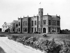 Mrs Gordon, Pitcalzean, Nigg. Copy of Dunskaith House, Nigg. The original house is at the far left, but it was significantly enlarged between 1901 and 1906 after its purchase by the Romanes family. The Cromarty Firth was used as a naval base during World War One, and Dunskaith House briefly became a naval hospital, but because of poor water supply to the house it was turned into a naval supplies store. It stood near to the Nigg pier and was almost wholly destroyed by fire in 1960 with only the servants' quarters surviving. *