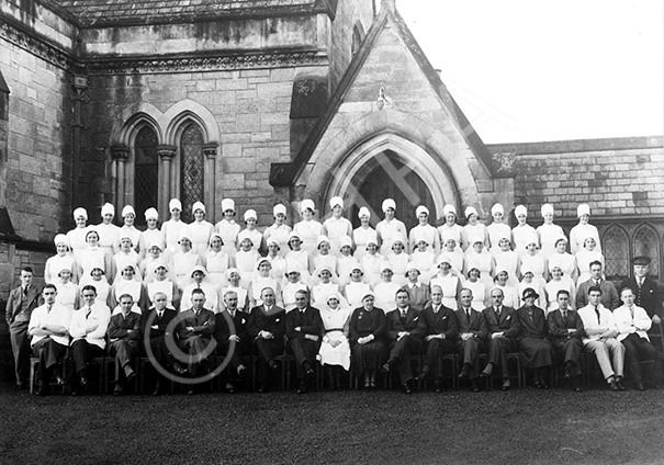 Copy for Gilbert Ross (seated fifth from the right) of nursing staff group outside the Infirmary in February 1957.