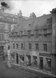 Church Street Inverness, showing fishmongers and old roofing, building built in 1700 for James Dunbar of Dalcross. By mid-19th century it was occupied by tradespeople, and was demolished in 1900. The site later housed the Clydesdale Bank and the four triangular pediments were preserved inside the building. They have not been seen however, since the bank moved premises in the 1980s. The corner building is now a bar called The Room.*