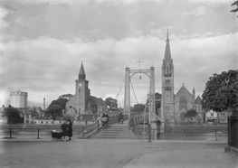 Greig Street Bridge over the River Ness, Inverness, showing old gasworks, cyclist and mothers with pram. (See also image H-0194a & H-0194b). *