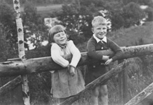 Mrs Seex, two children on a wooden gate. 