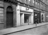 Robb in Union Street, Inverness. The Art Deco facade has gone and is now occupied by the British Heart Foundation, with the Glass & China Warehouse next door now housing Jessops. Further along, Stewart's Bar is now MacCallums. The carved stone face above the heavy door at the left has also disappeared, although others along the facade of the building (The White House Bistro) remain.* 