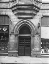 Street level facade of the Inverness Town House in Castle Street, built between 1878-1882. To the left of door no.6 was an opticians, who also dealt with health insurance, cameras and film. To the right was W.H. Finlay & Co, Publishers & Stationers - 'Official Printers to Inverness' with an office in London. *