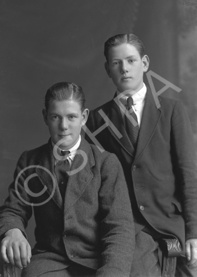 Two young men, one seated, possibly brothers.#    