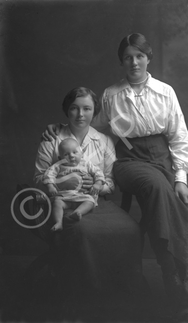 Two women, one holding a baby.#