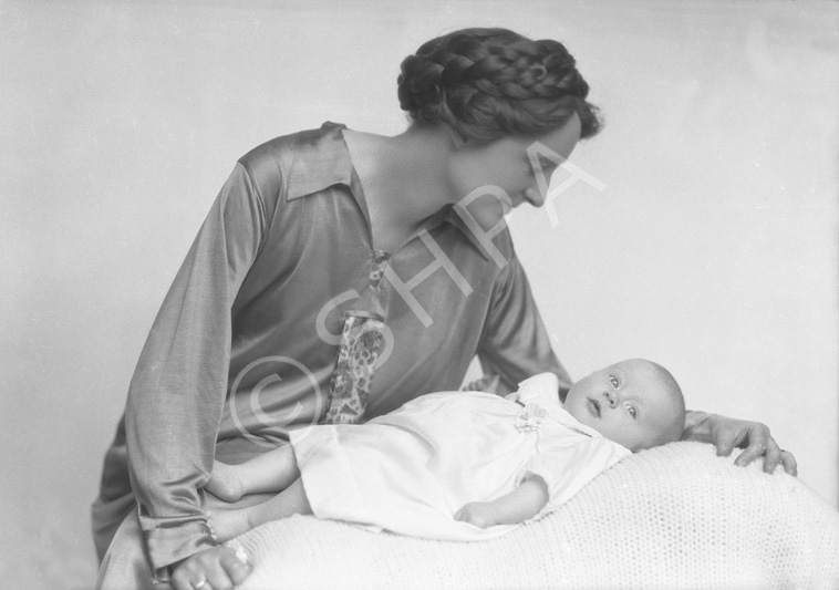 Mother with braids in hair looking over new baby.#