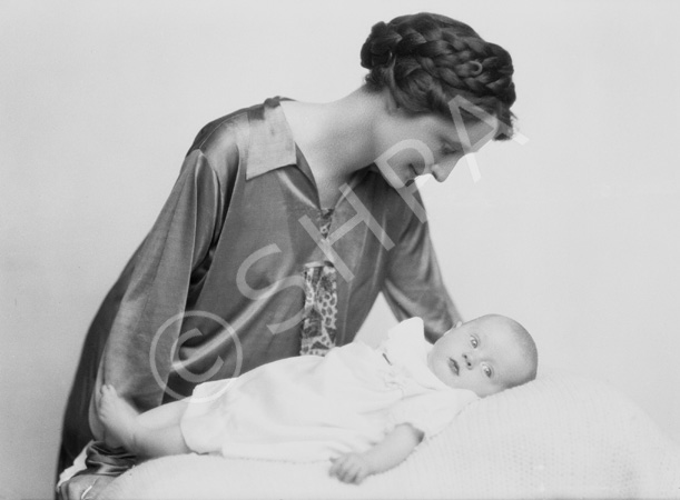 Mother with braids in hair looking over new baby.#