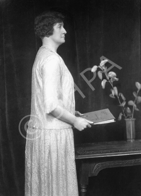 Woman with book, profile, standing. # 