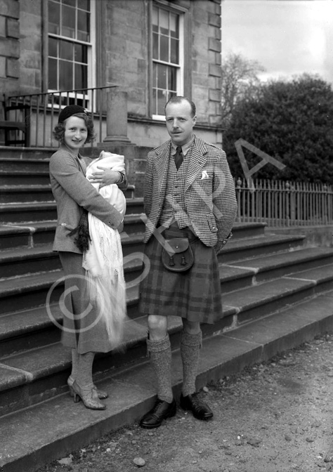 Parents on steps, at time of baby christening.#