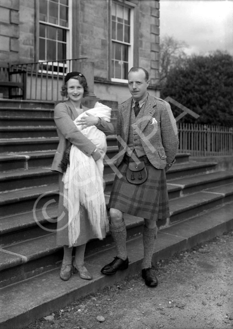 Parents on steps, at time of baby christening.#