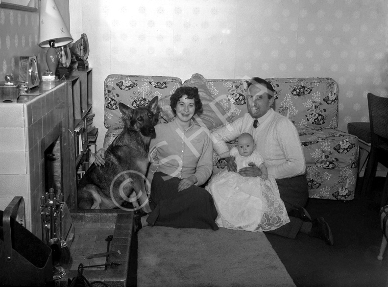 Family and dog in sitting room, taken for a Christmas card. Name on envelope is Helen Marie. #