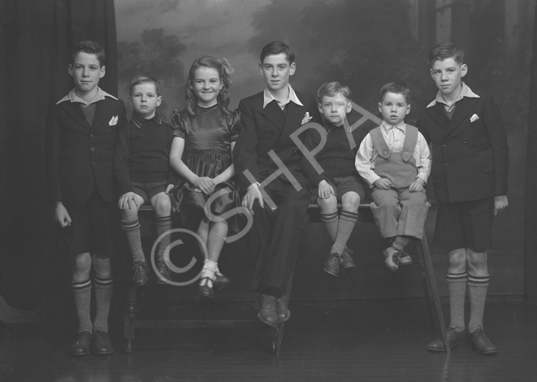 Stewart, Kessock Avenue, Inverness. Jimmy (far left) was twin brother to Sandy (far right). Willy (second left) was twin brother to Robert (third right). Mary and John. John was born a twin to Peter who died at 3 months. George Stewart (second right) is the only surviving sibling (2012). Unsure why the negative envelope has the address as Kessock Avenue. The Stewart family lived in Maclennan Crescent, Inverness.
