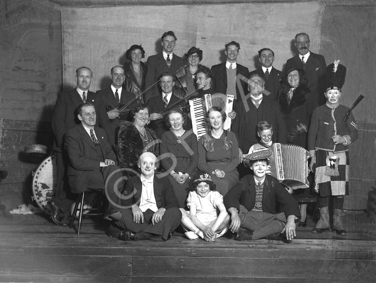 Group of people including musicians and clowns. #